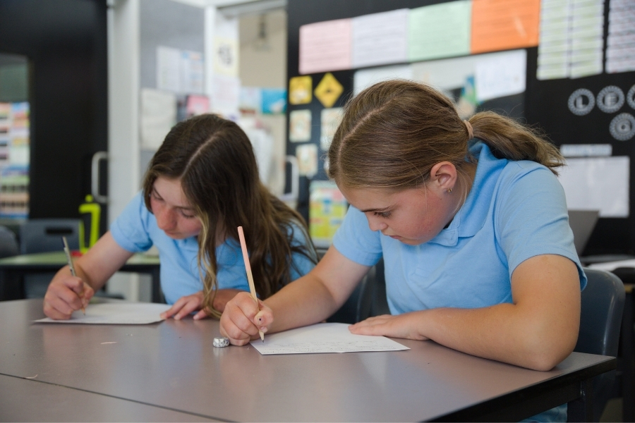 Two students writing their informative texts